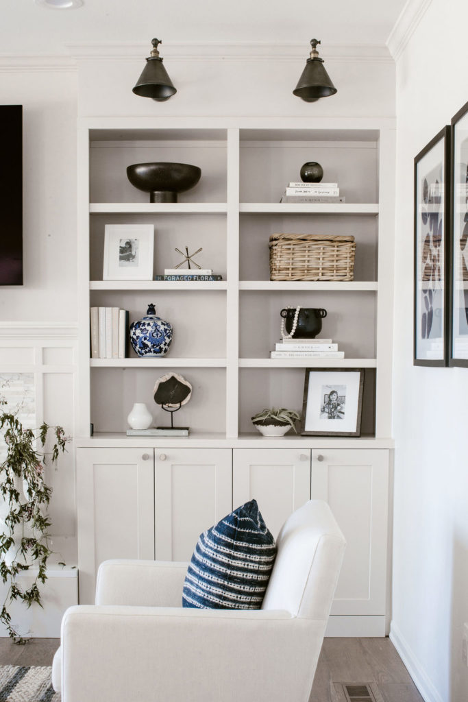A white and blue living room with custom built-ins and matte black finishes
