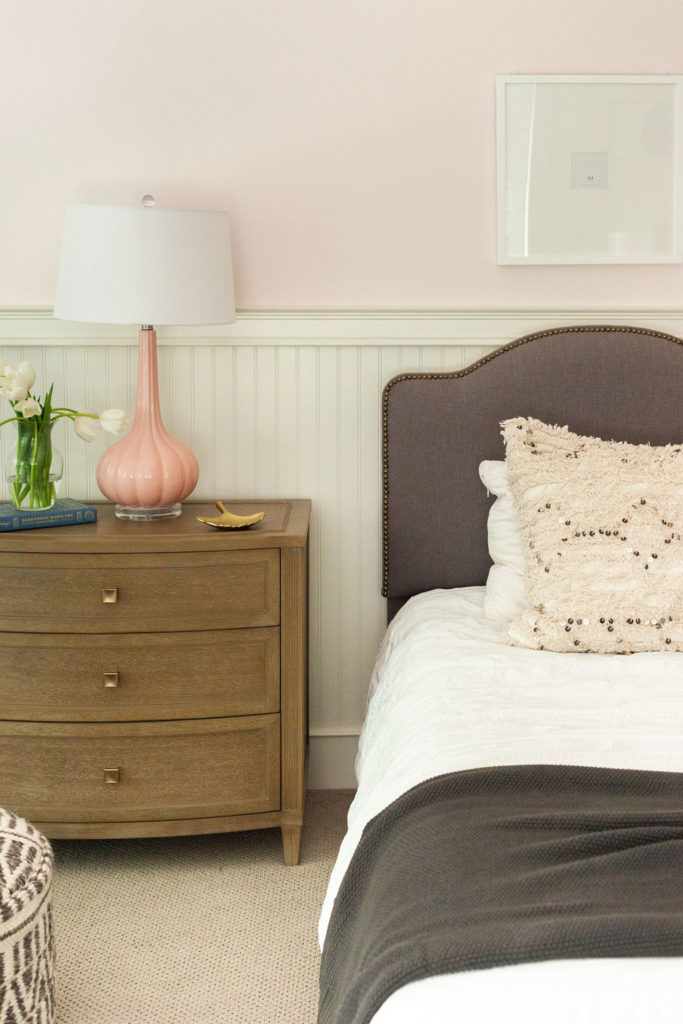 pink lamp on nightstand next to bed